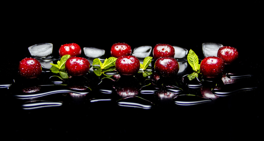 fresh cherries with mint leaves and pieces of ice
